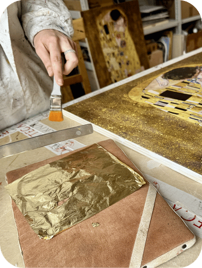 Applying gold leaf during a traditional gilding process in a art workshop in Umbria